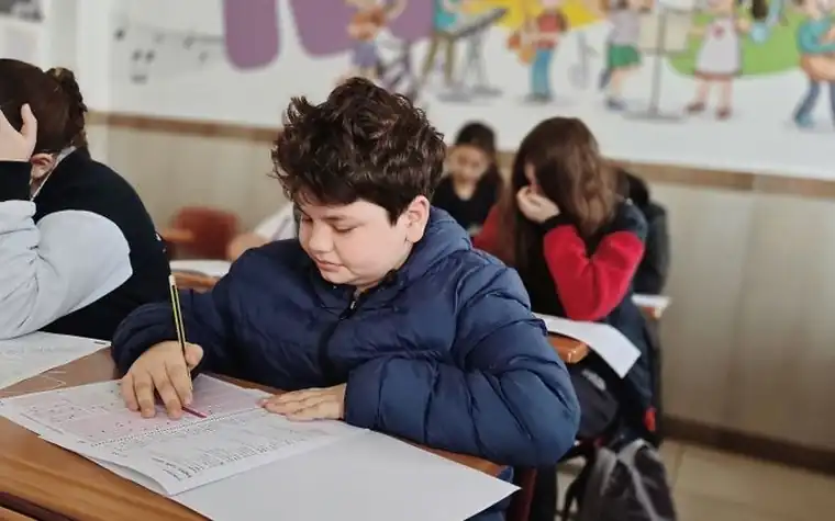 교실에서 시험지를 앞에 두고 집중하는 학생들