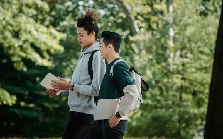 책가방을 메고 캠퍼스를 걷는 학생들의 모습