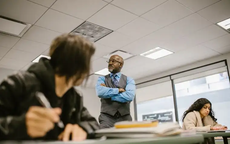 A proctor watching a student during an exam