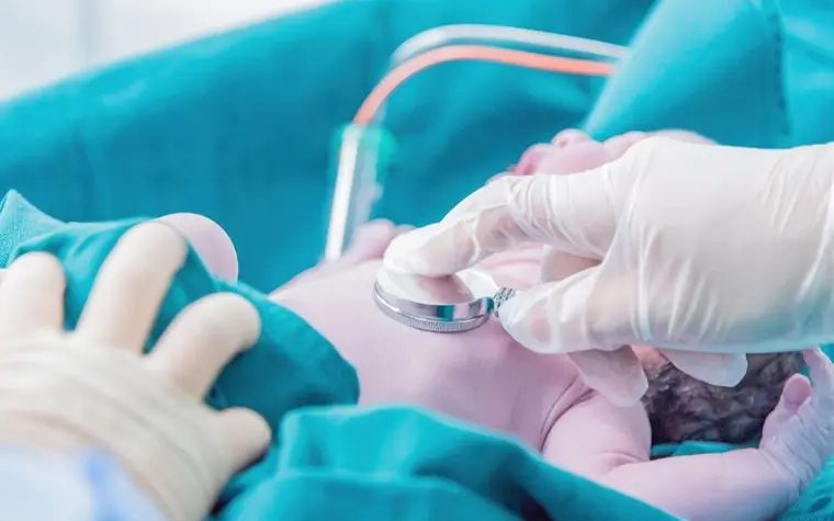 A newborn baby sleeping in a hospital bassinet
