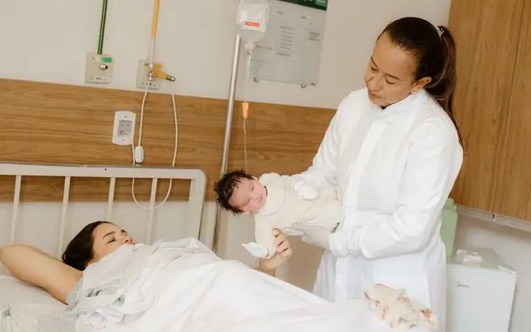 A doctor caring for a mother holding her newborn baby