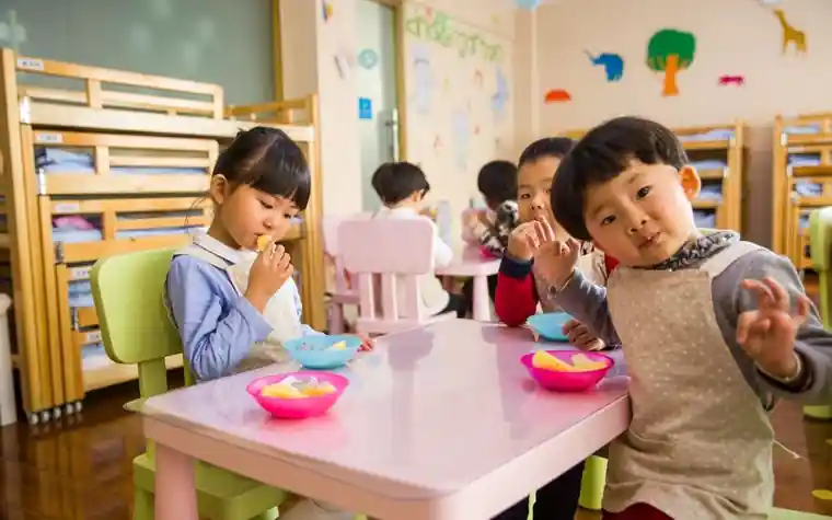 어린이집 교실에서 식탁에 둘러앉은 아이들