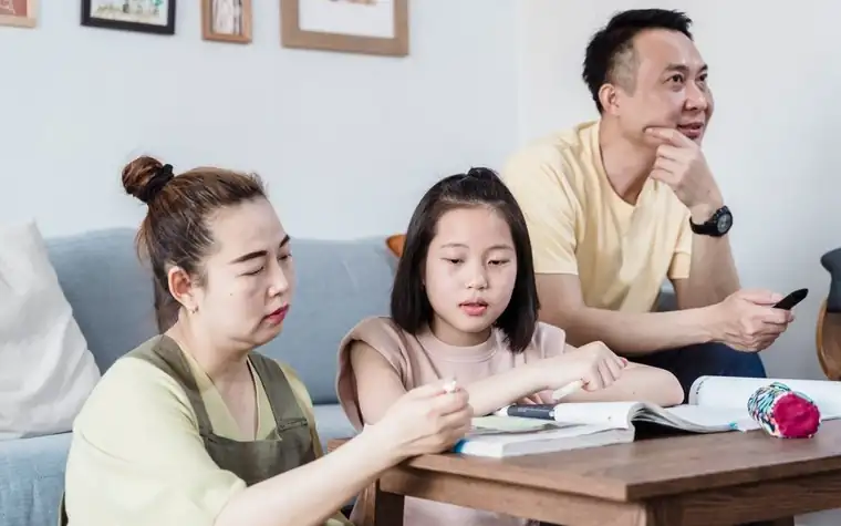 부모가 식탁에서 자녀의 학습을 함께 살펴보는 모습