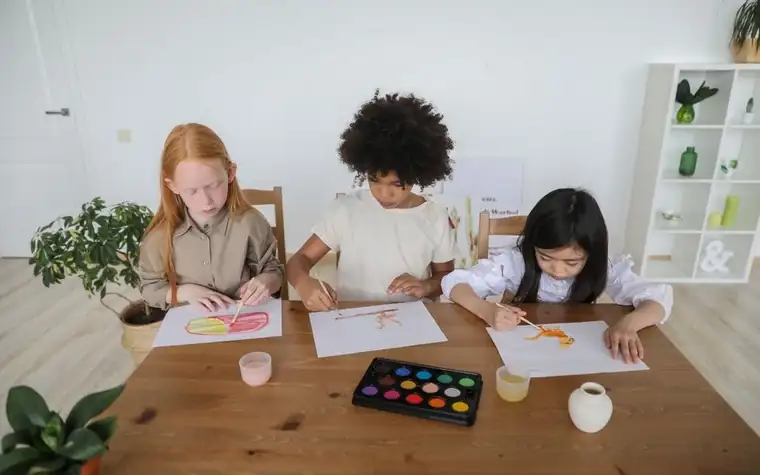 Girls sitting around a table drawing together