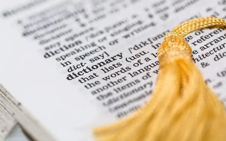 A dictionary open on a desk while studying