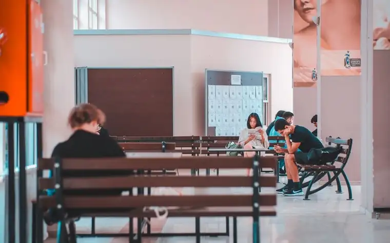 Students waiting their turn on a bench in a school lobby