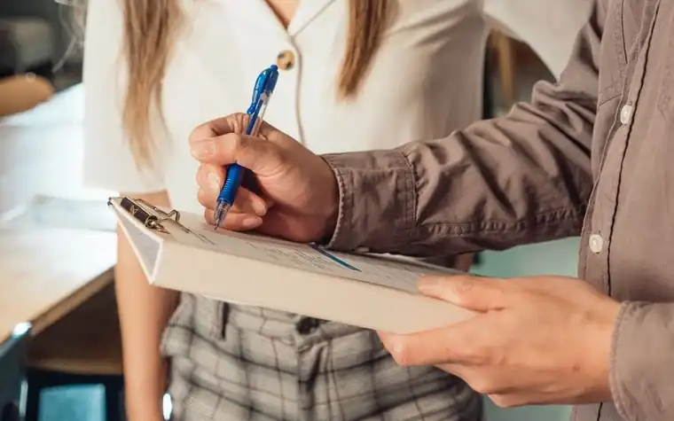 Filling out a document attached to a clipboard by hand
