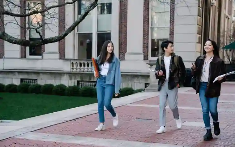 햇빛이 드는 대학 캠퍼스를 걸어가는 학생들