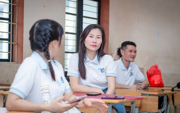 교실 책상에서 마주 앉아 이야기를 나누는 교사와 어른들