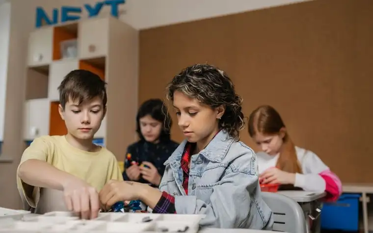 Children working together on assembling parts in a classroom